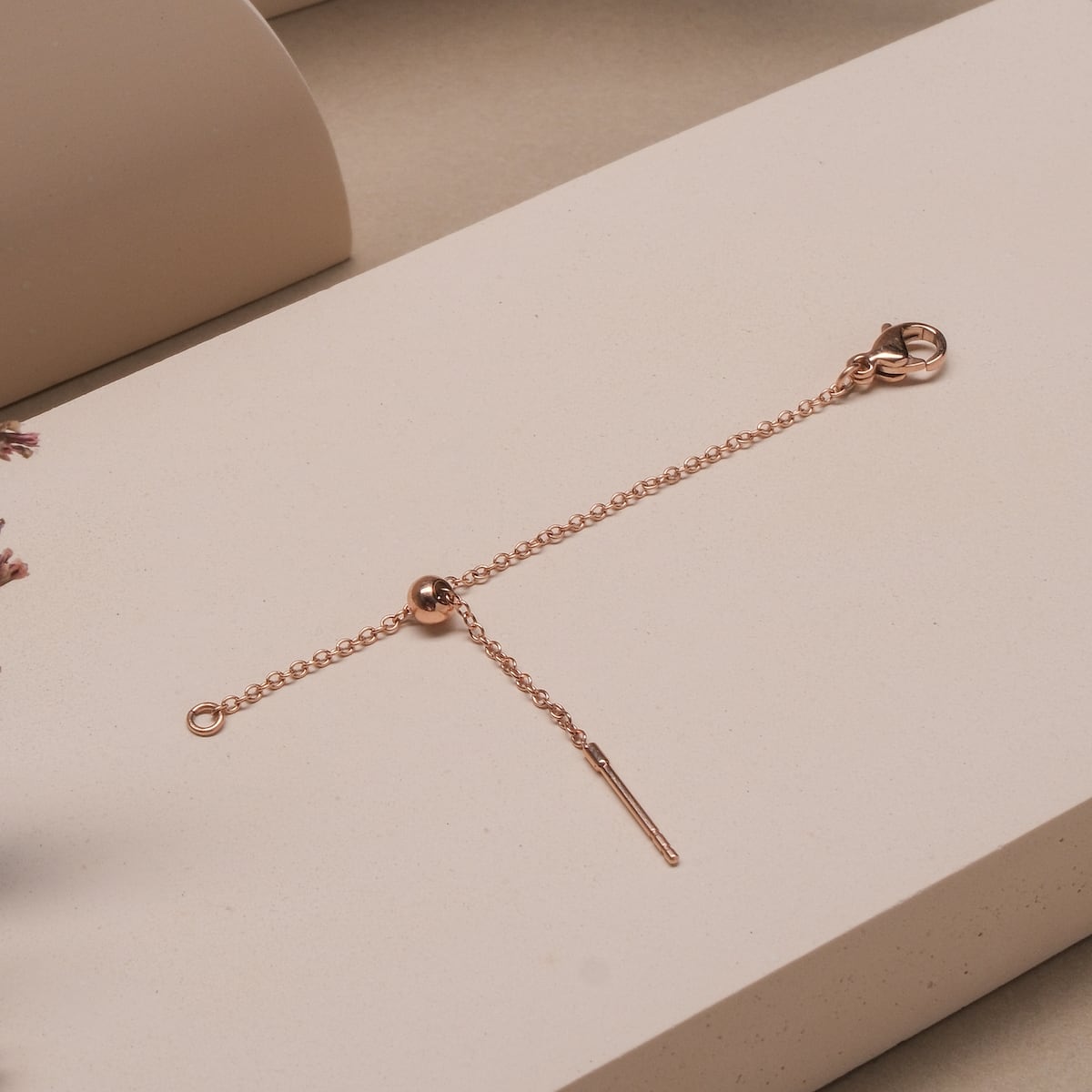 "Jewelry Extender", a rose-colored jewelry extender, featuring a delicate chain design.