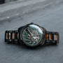 "Adrenin watch featuring a Cat's Eye pattern and walnut accents, with an intricate dial design and stylish metal band."