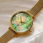 "Sunnyside" watch, featuring a nacre dial and gold mesh band.