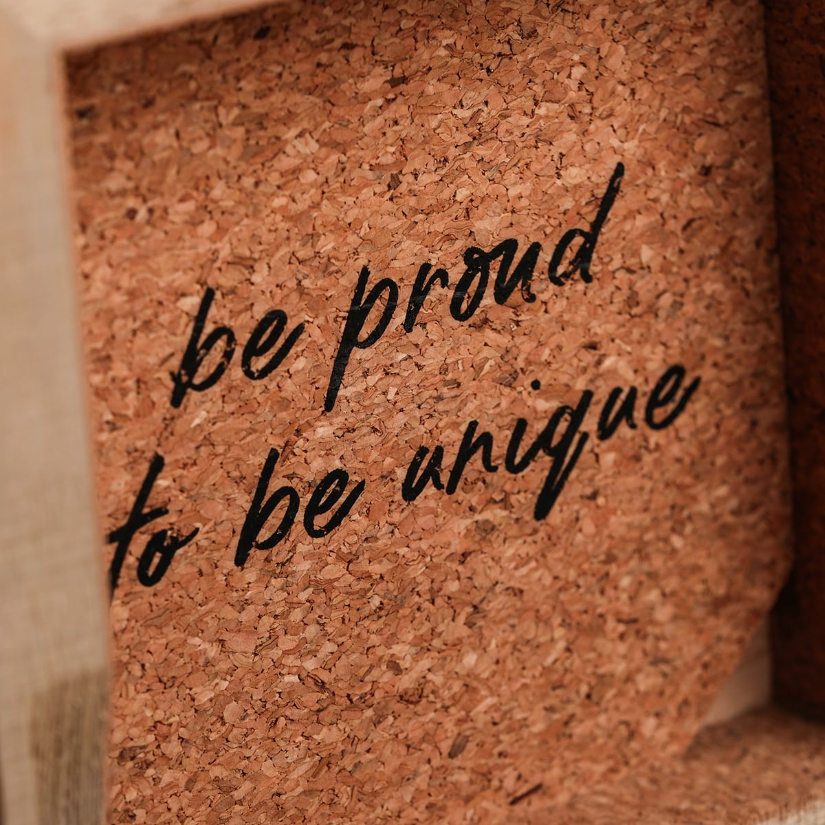 Boîte en bois avec doublure en liège et texte de motivation en écriture noire élégante.