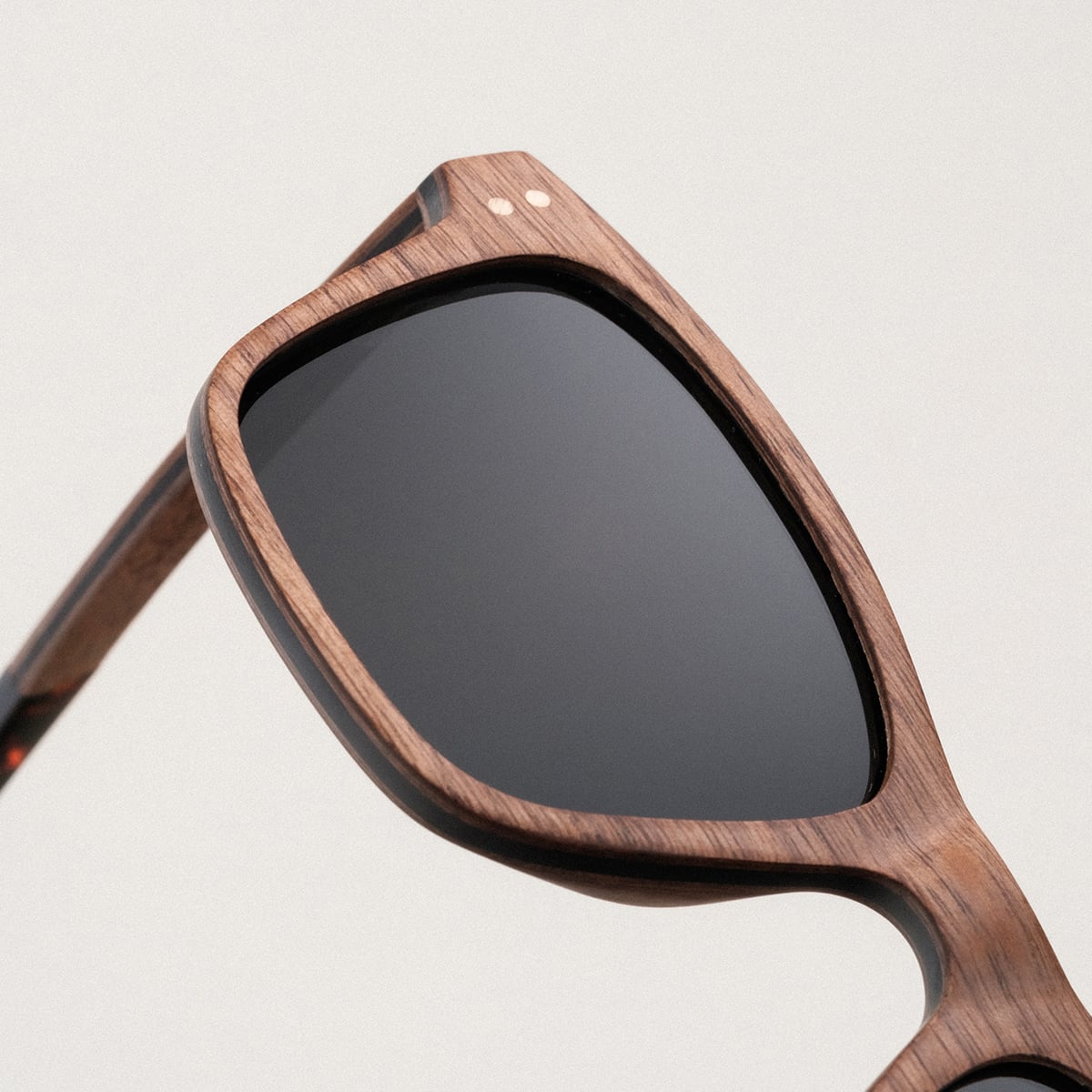 "The Extrovert" sunglasses in walnut finish, featuring a sleek, modern design.