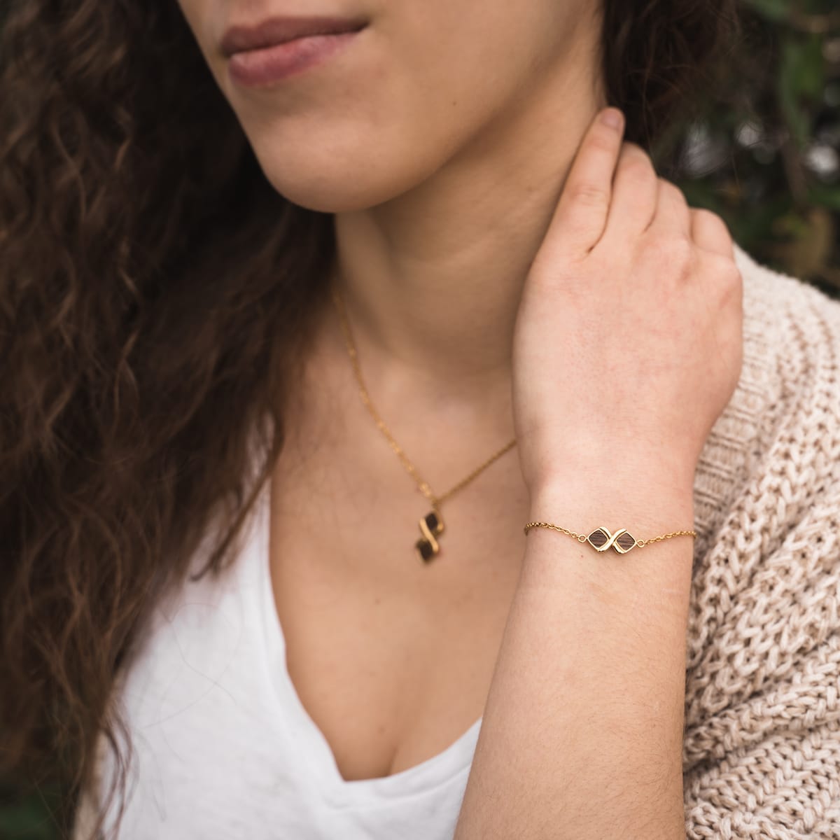 "Mosaic Bracelet" bracelet with a walnut and gold mosaic design, worn on a woman's wrist, complements a casual outfit.