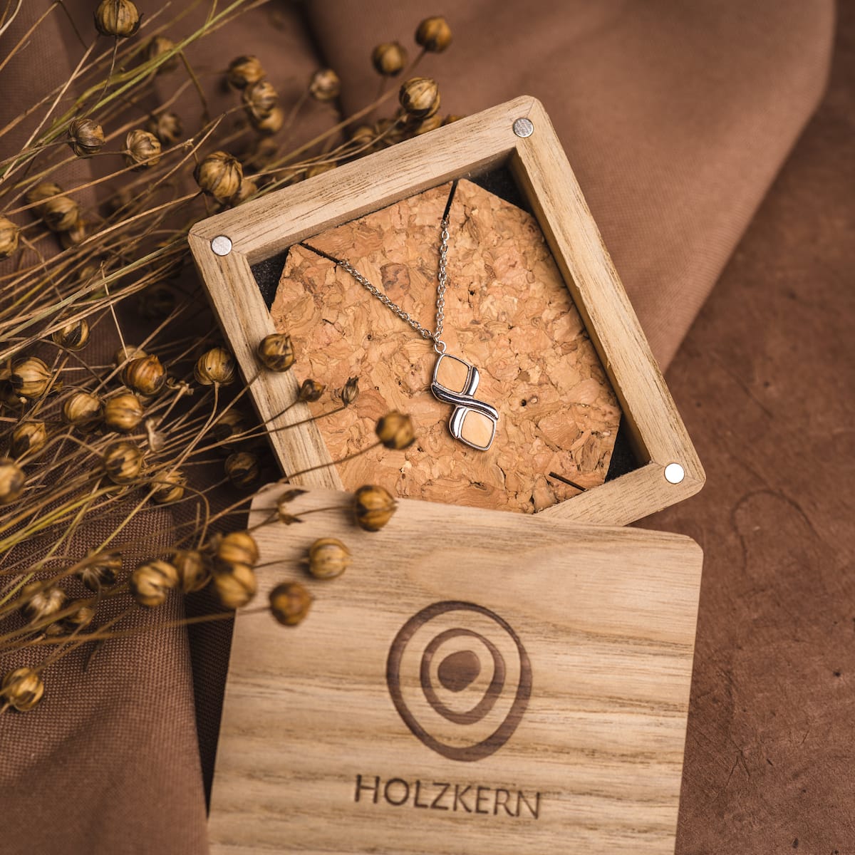 Collier "Mosaic Collier", avec des accents olive et argent, élégamment exposé dans une boîte en bois.