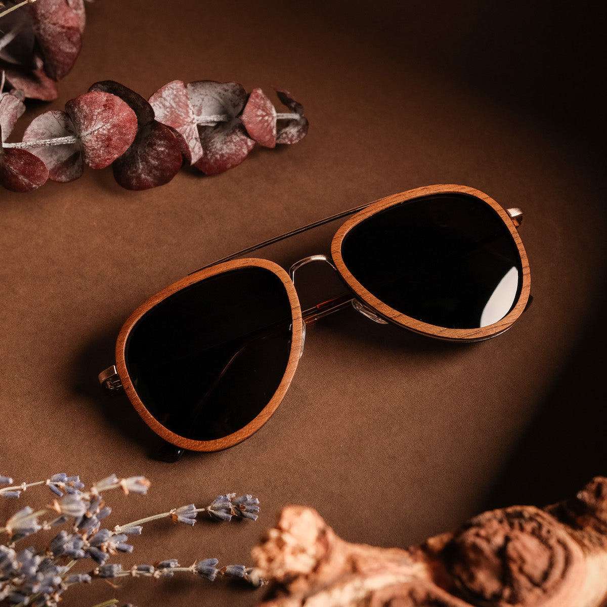 "The Honorable" sunglasses, featuring a teak frame and matte gold accents with a stylish, earthy aesthetic.
