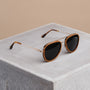 "The Honorable" sunglasses featuring a teak and matte gold finish with a modern, stylish design.