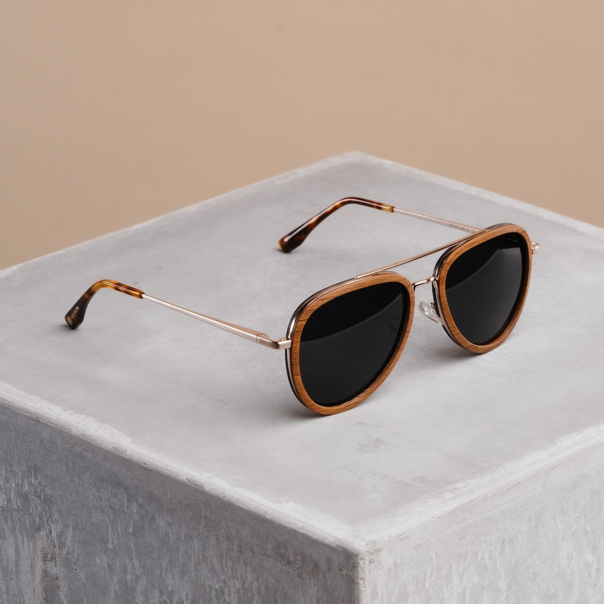 "The Honorable" sunglasses featuring a teak and matte gold finish with a modern, stylish design.