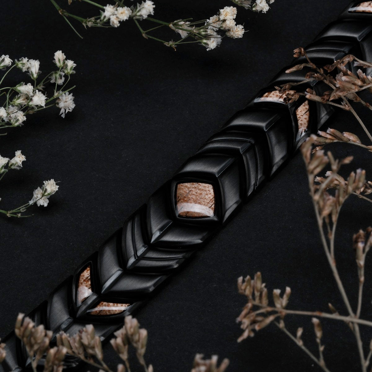 "Prelude", a decorative item with a koa and black design, set against a dark floral backdrop.