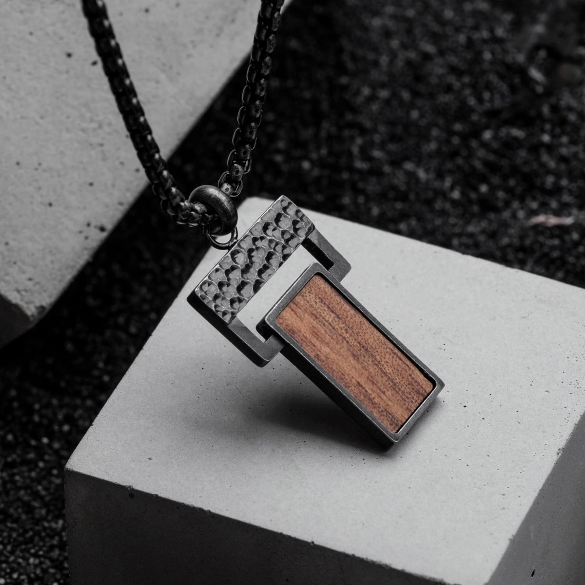 "Transcendent" necklace with koa wood and antique silver accents, showcasing a modern, textured design.