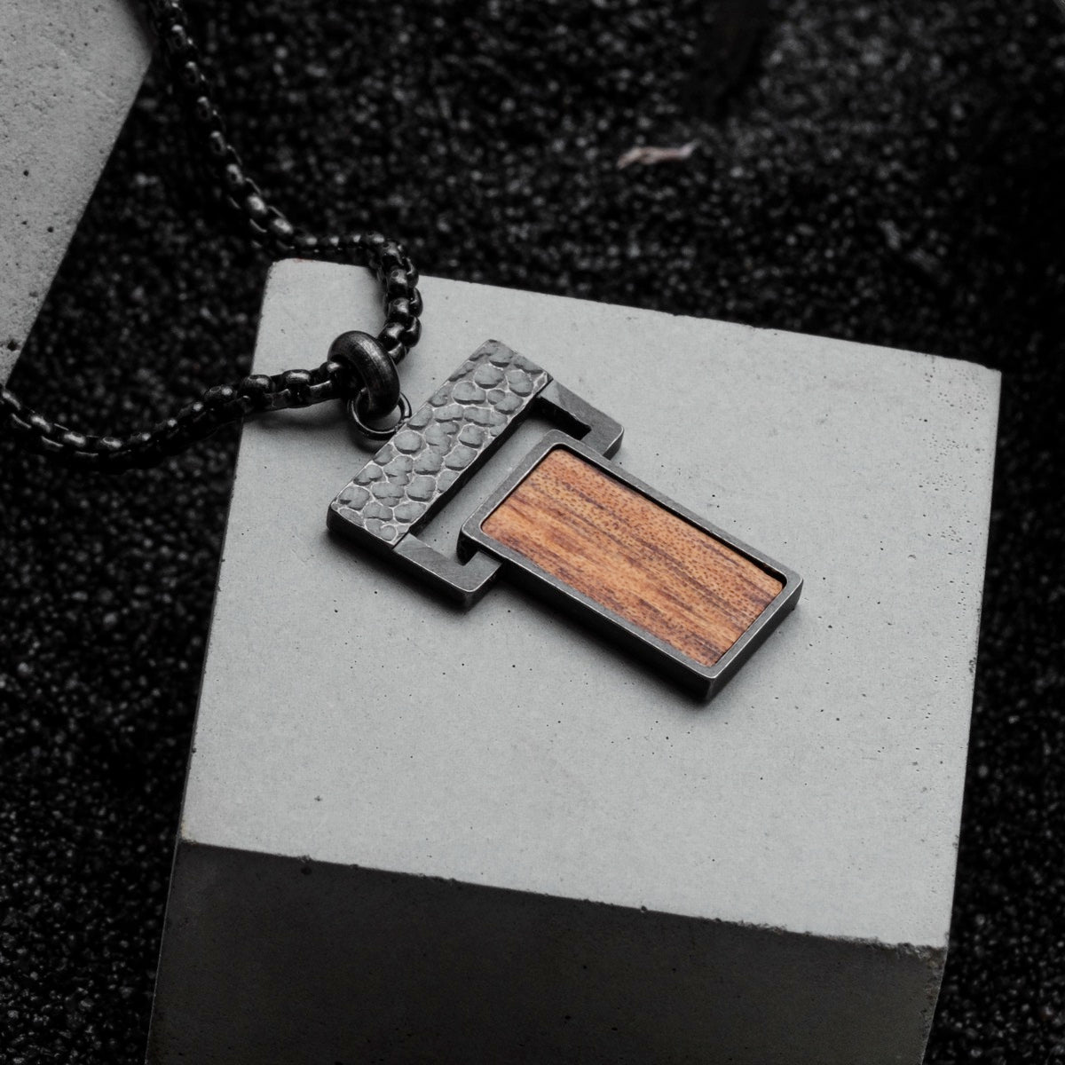 "Transcendent" pendant featuring koa wood and antique silver finish with a textured, modern design.