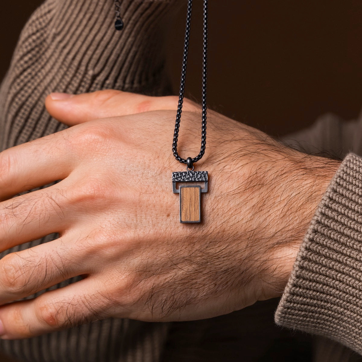 "Transcendent" necklace featuring a Koa wood and antique silver design, showcasing a sleek, modern style.