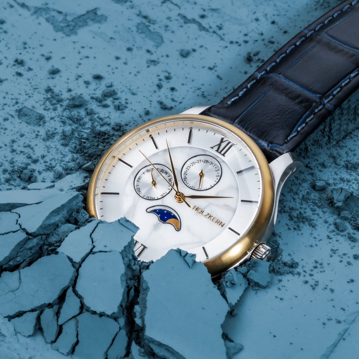 "Moonrise" watch featuring a marble dial and dark blue leather strap, set against a textured blue background.