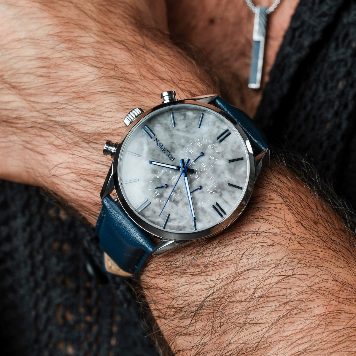 "Gifted" wristwatch features a marble dial and blue leather strap, blending elegance with contemporary style.