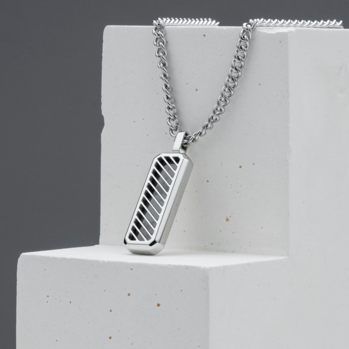 "Interplay Necklace" necklace with a gray marble and silver design, featuring a modern rectangular pendant.