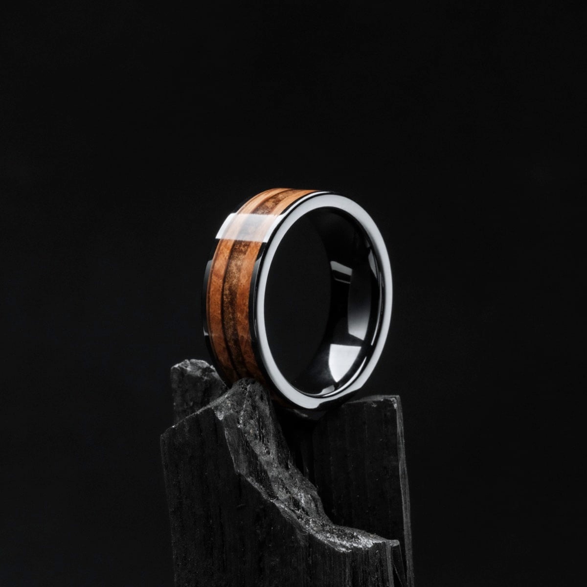 "Sumo Ring" - A ring crafted in whiskey wood and ceramic, set against a dark, sophisticated backdrop.