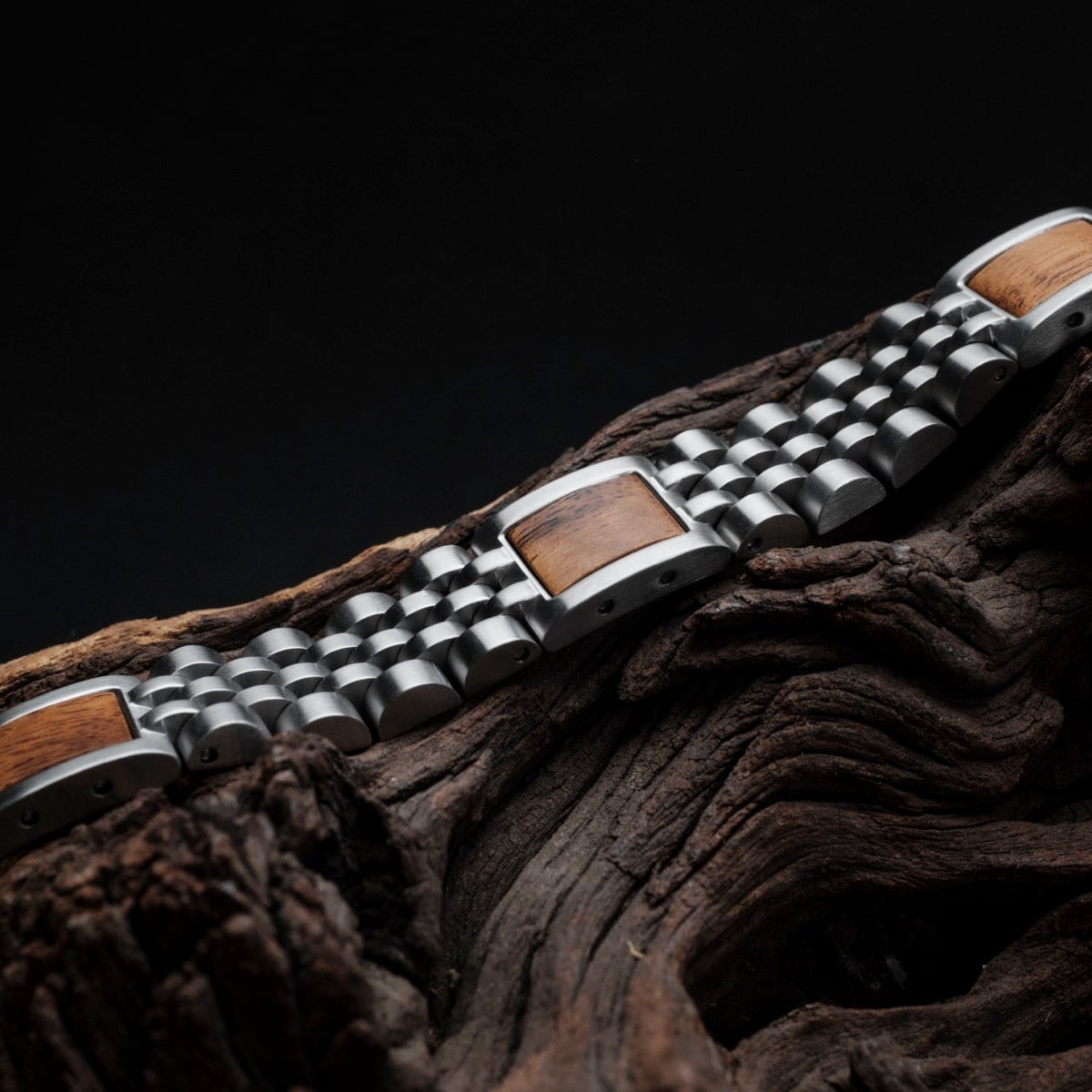 "Pentachord" armband met Koa houten accenten en zilveren schakels, op een donkere achtergrond.