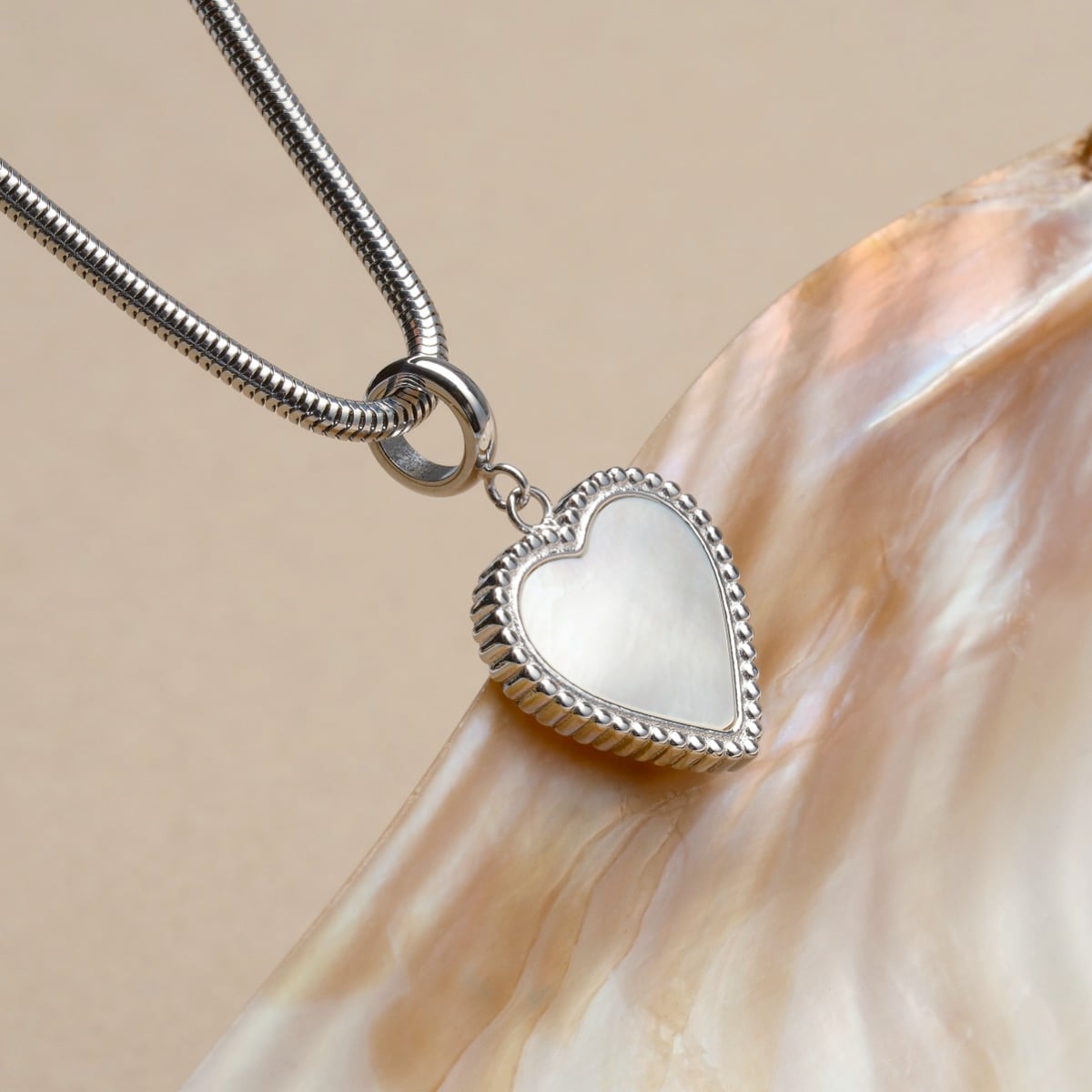 "Amorance Necklace" heart necklace featuring a nacre pendant with silver accents, showcasing elegant and sophisticated design.