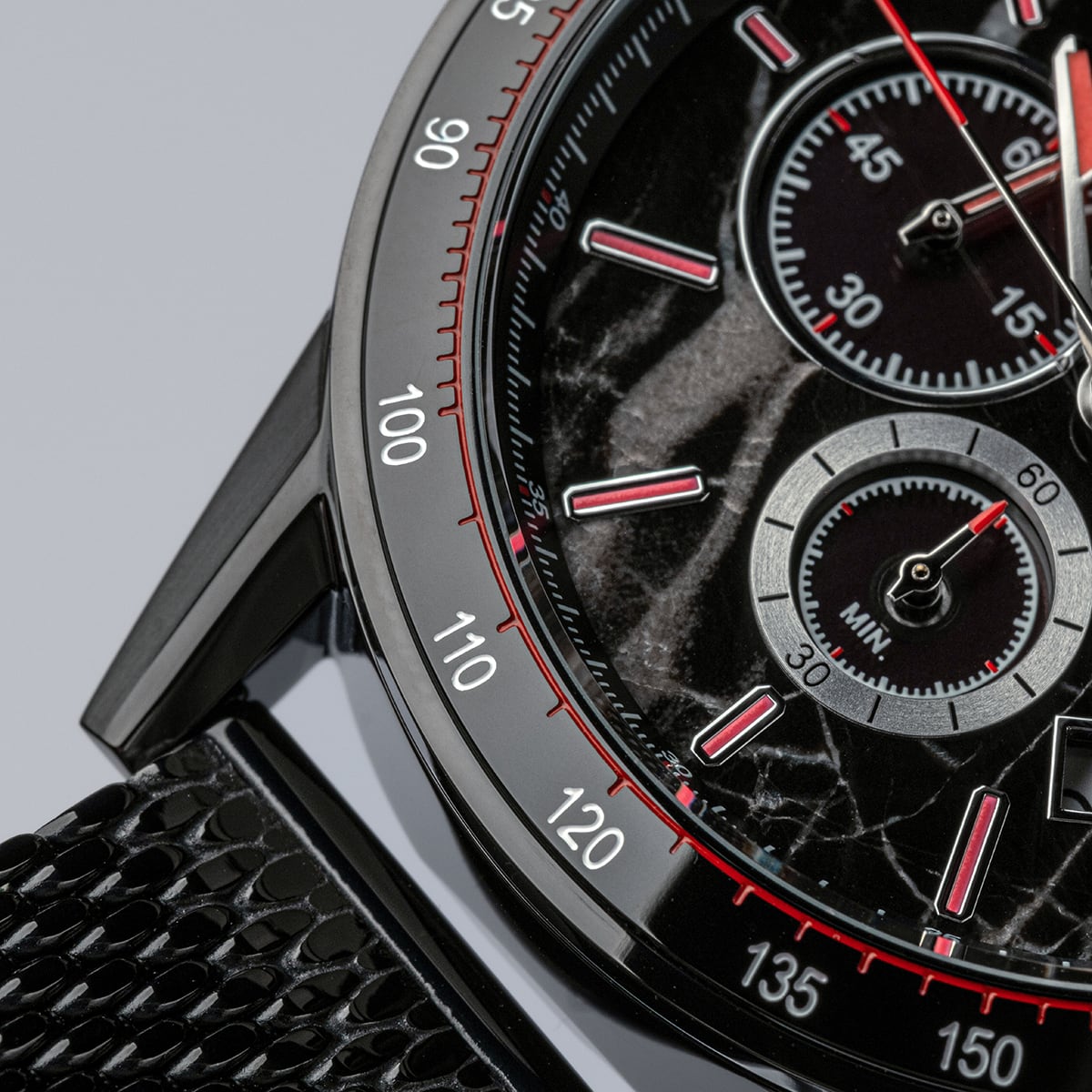 "Comfort Crusher" watch featuring a marble black face with red accents and a textured black band.