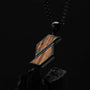"Collares de baritona": Cebrawood y collar negro con diseño geométrico en un fondo oscuro.