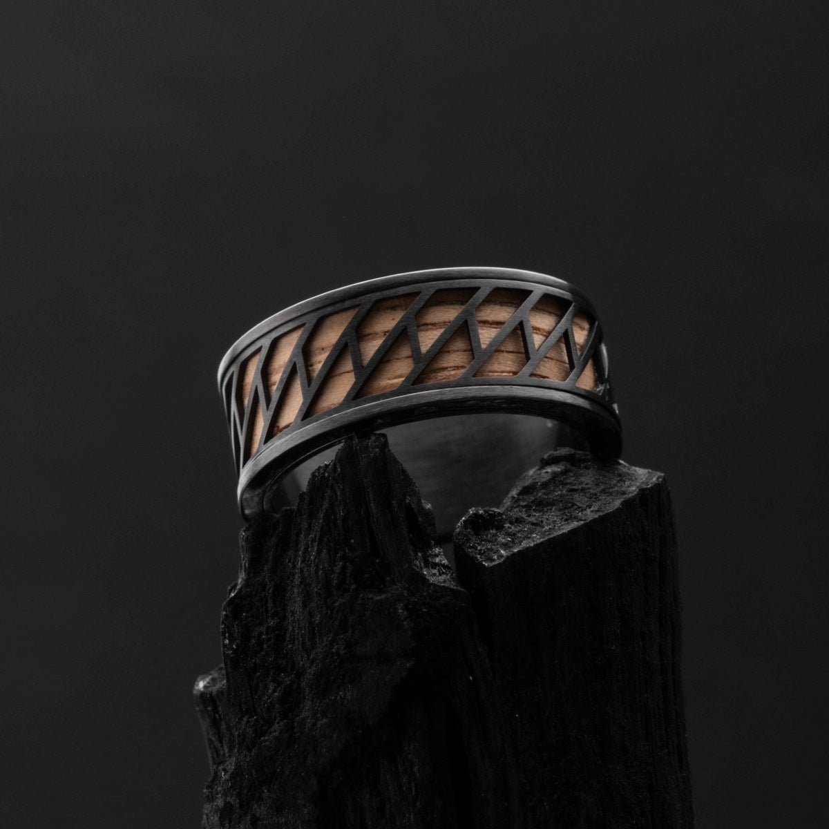 "Baritone Rings", a stylish ring featuring zebrawood and black accents on a dark background.
