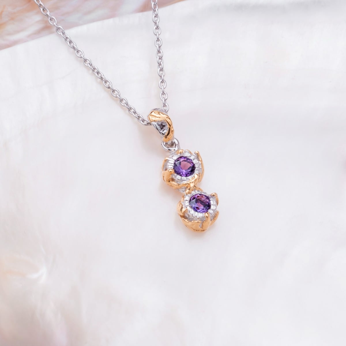"Silverstream Necklace": elegant necklace featuring amethyst stones set in gold with a sophisticated design.