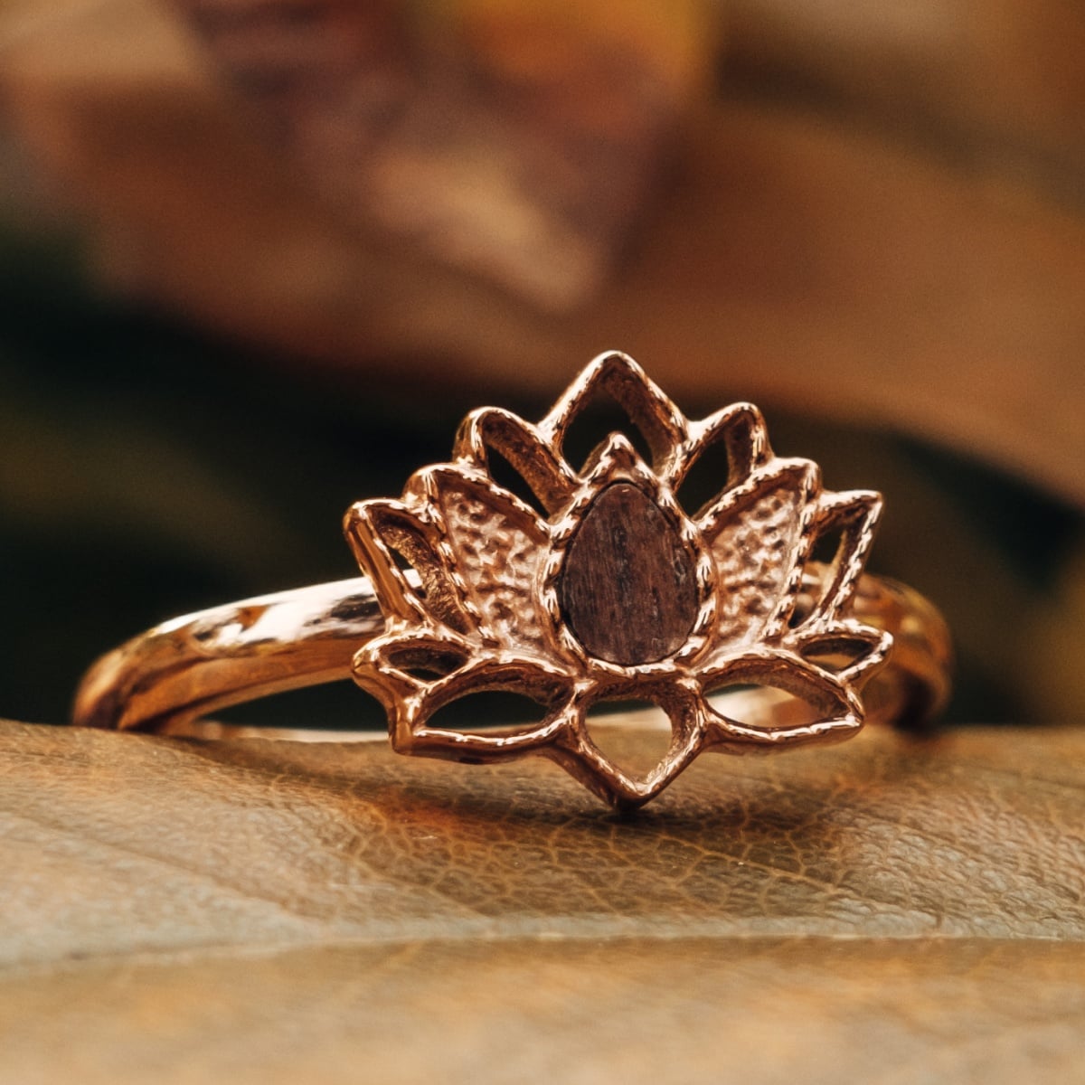 "Balance Ring": A walnut and rose gold ring featuring an intricate floral design.