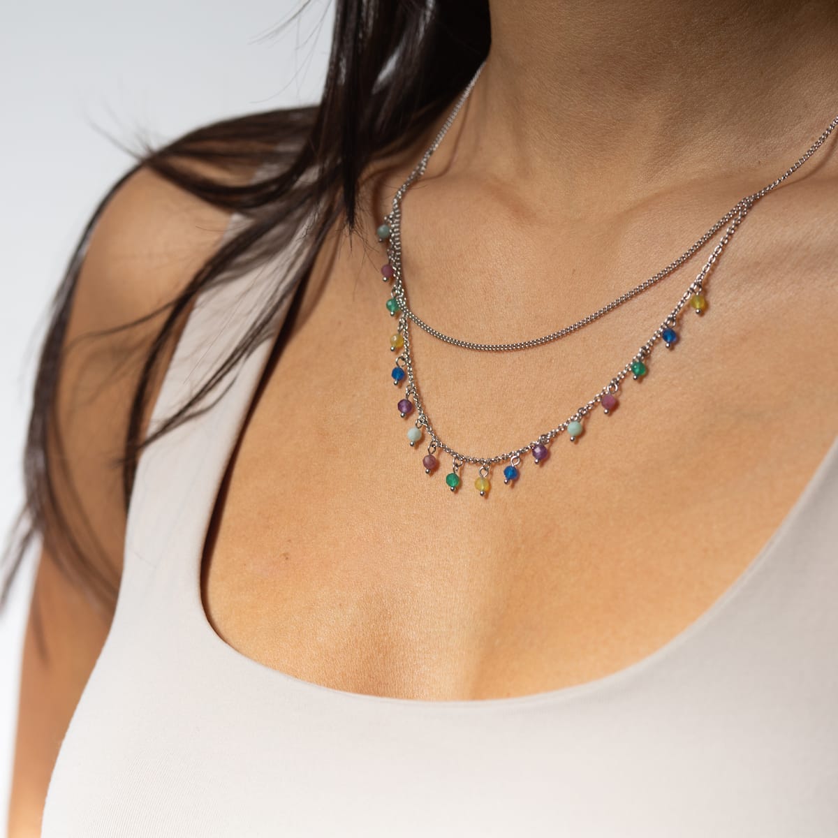 "Free Play Necklace": Colorful beaded necklace in rainbow and silver tones, adding elegance and charm to any outfit.