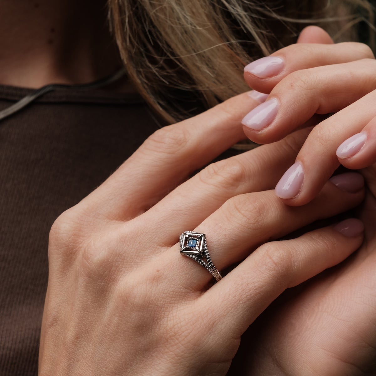 "Awakening Ring": Elegant silver ring featuring a lapis lazuli stone, worn on a hand showcasing its intricate design.