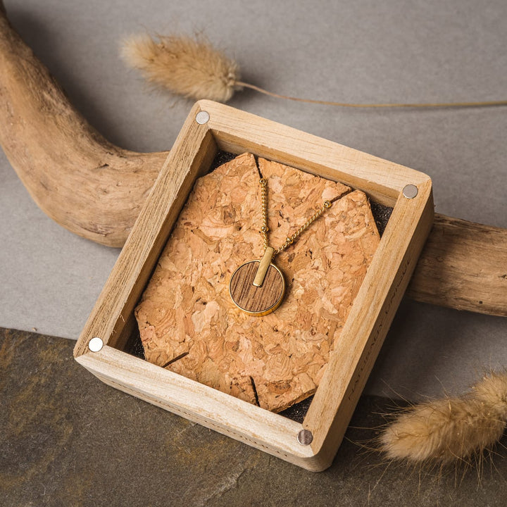 Collier "Opacity Collier" en bois de marbre et or avec un style rustique et élégant dans une boîte à affichage artisanale.