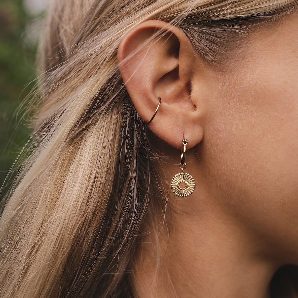 "Stencil Earrings" are elegant earrings featuring a circular gold design with a unique stencil pattern.
