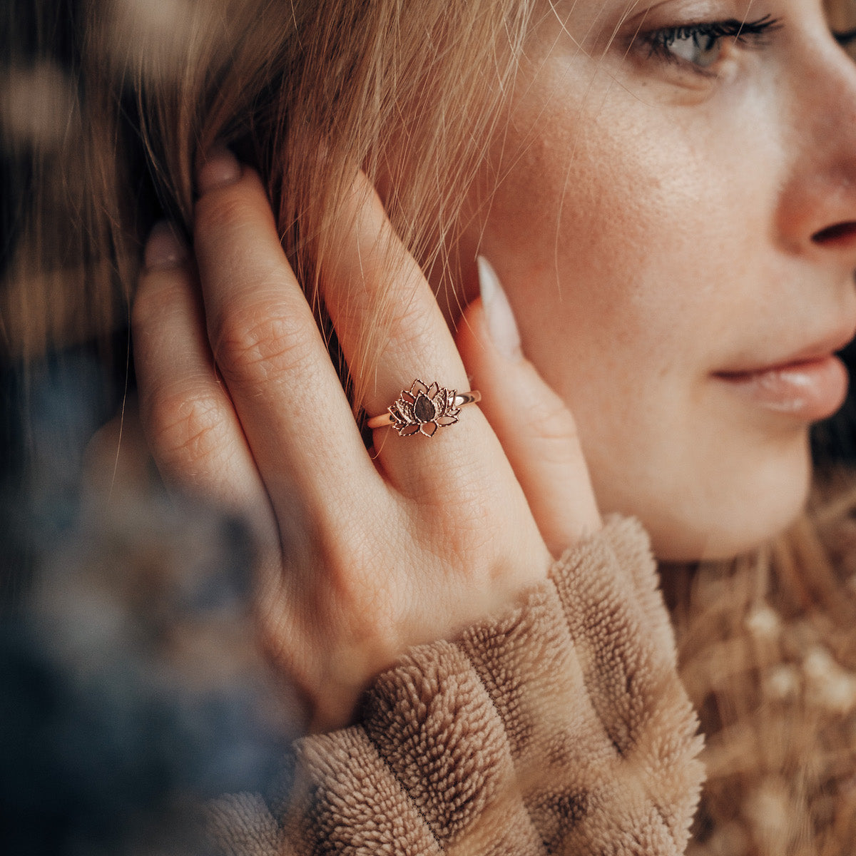 "Balance Ring" ring featuring a walnut and rose gold design, worn on a woman's hand, showcasing elegance and style.