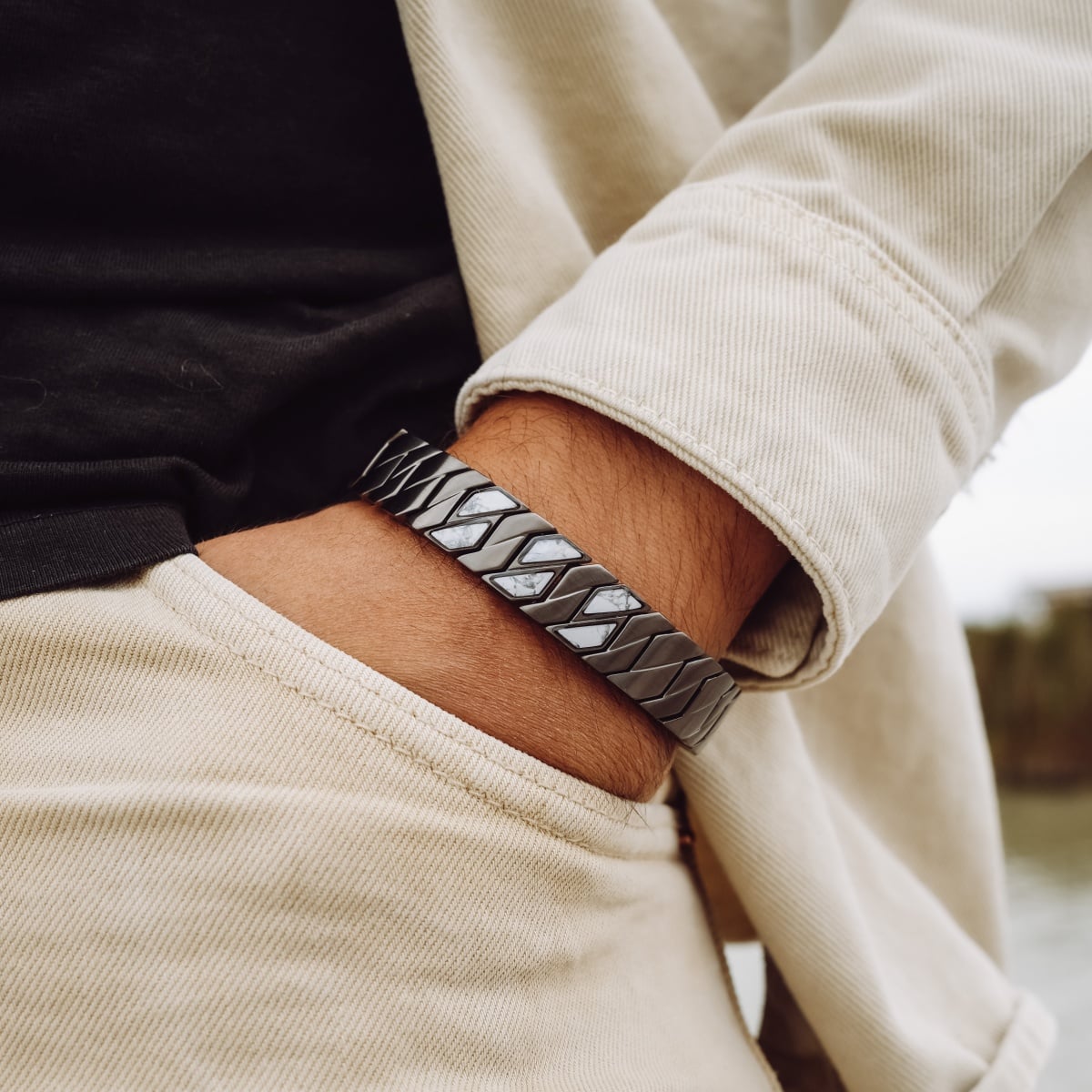 "Baritone" bracelet featuring a sleek dark grey and howlite design, worn in a casual style.