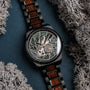 "Adrenin watch featuring a stylish Cat's Eye face and Walnut accents, surrounded by decorative moss."