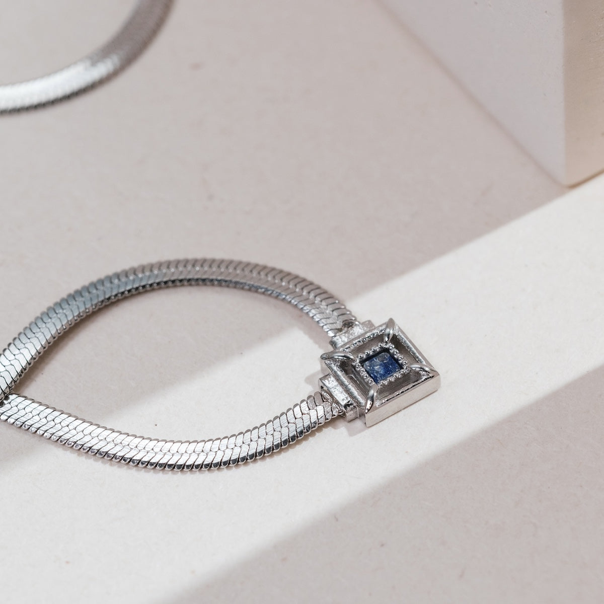 "Awakening Necklace" necklace featuring a sleek silver design and a striking lapis lazuli centerpiece.
