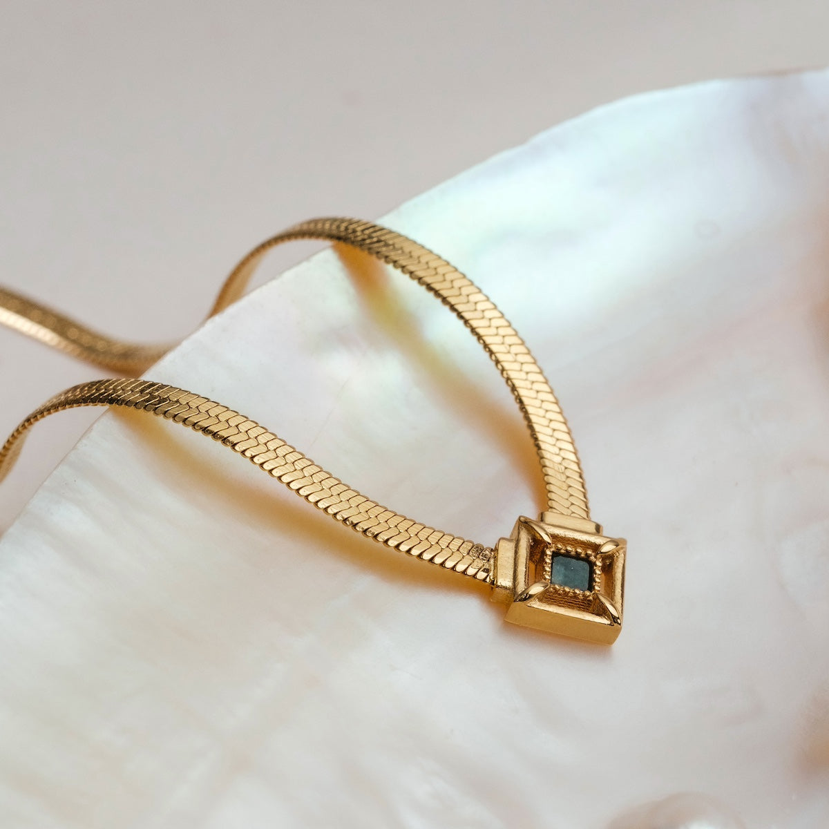"Awakening Necklace" necklace featuring a gold chain and marble-inset pendant with a luxurious, elegant style.