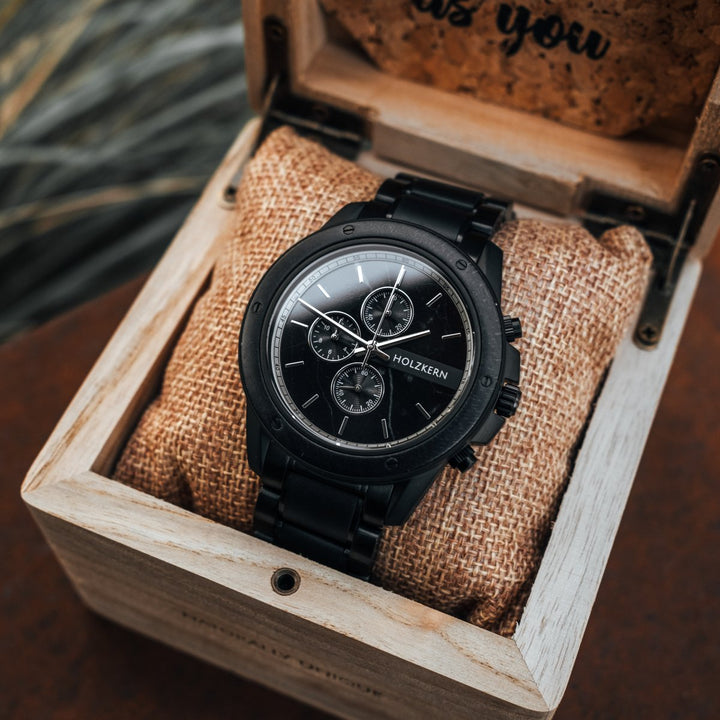 "Lucan" watch featuring a sleek black design with a stylish, detailed face, presented in an elegant wooden box.