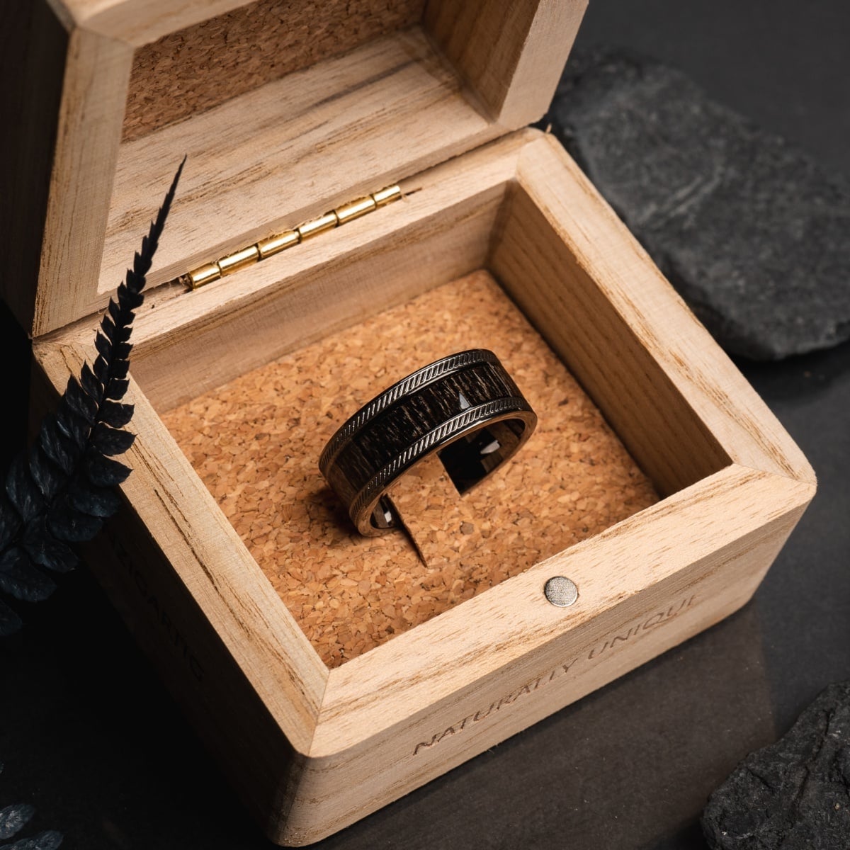 "Countless Ring", un anneau élégant en érable et gris foncé, élégamment exposé dans une boîte en bois.