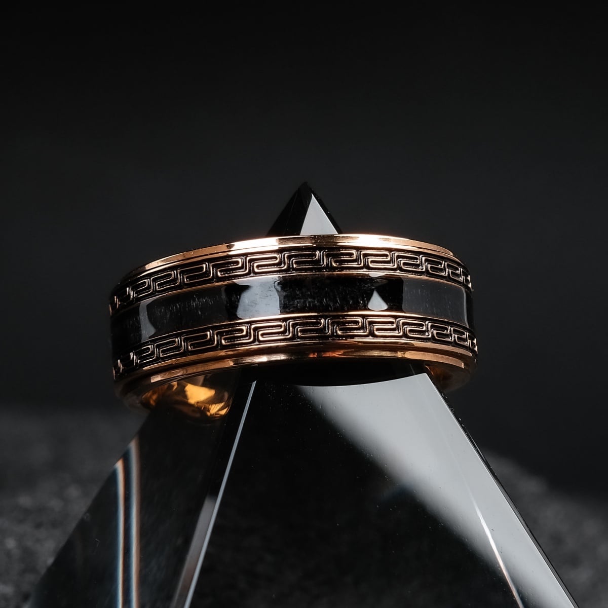 "Numerary Ring", a stylish ring featuring a maple and gold design with intricate geometric details against a dark background.