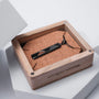 "Collana dei derivati", una collana elegante a ciondolo in Zebrawood e nero, visualizzata in una scatola di legno.