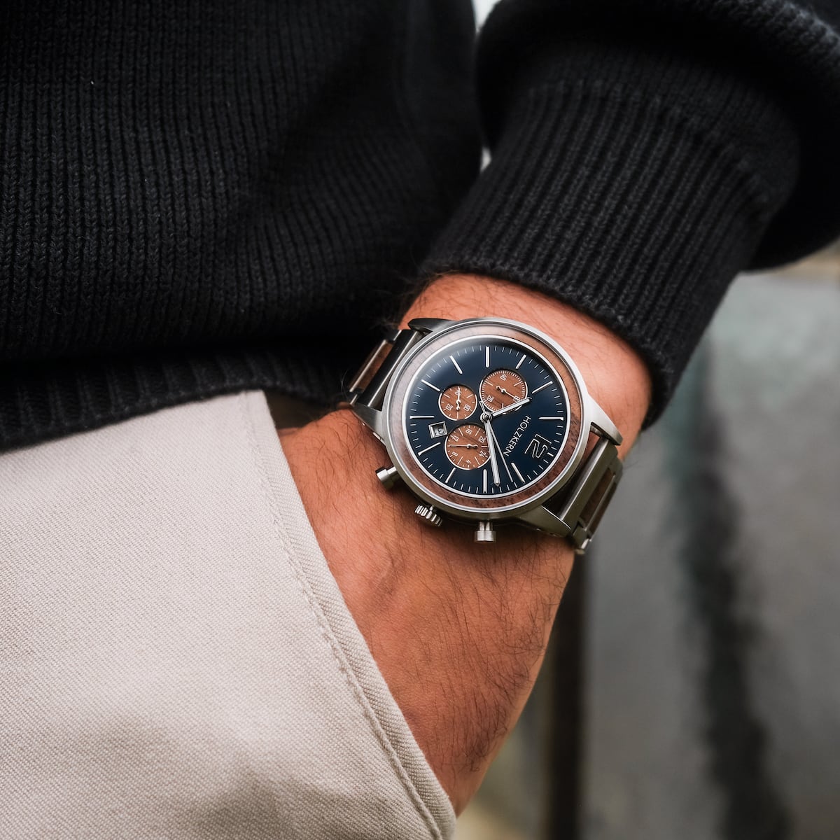 "Oscar" watch featuring a walnut finish and blue dial, worn by a person in casual attire.