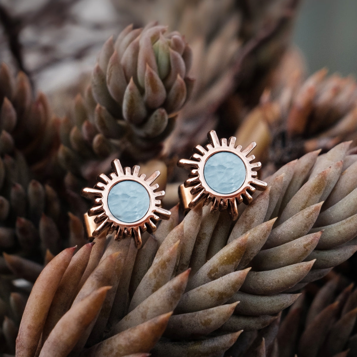 "Shade Earrings", elegant earrings featuring blue nacre and rose gold in a sunburst design.