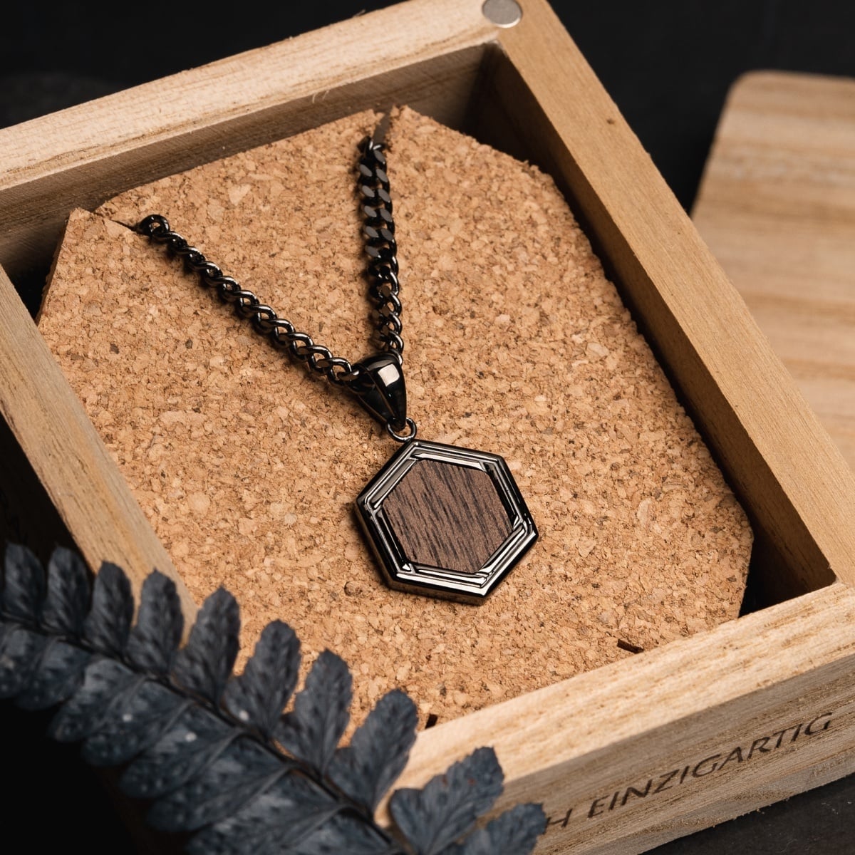 "Axis Necklace" necklace featuring a walnut insert and dark grey chain in a hexagonal design.