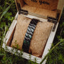 "Baritone" bracelet, featuring a marble and black design, elegantly presented in a rustic wooden box.