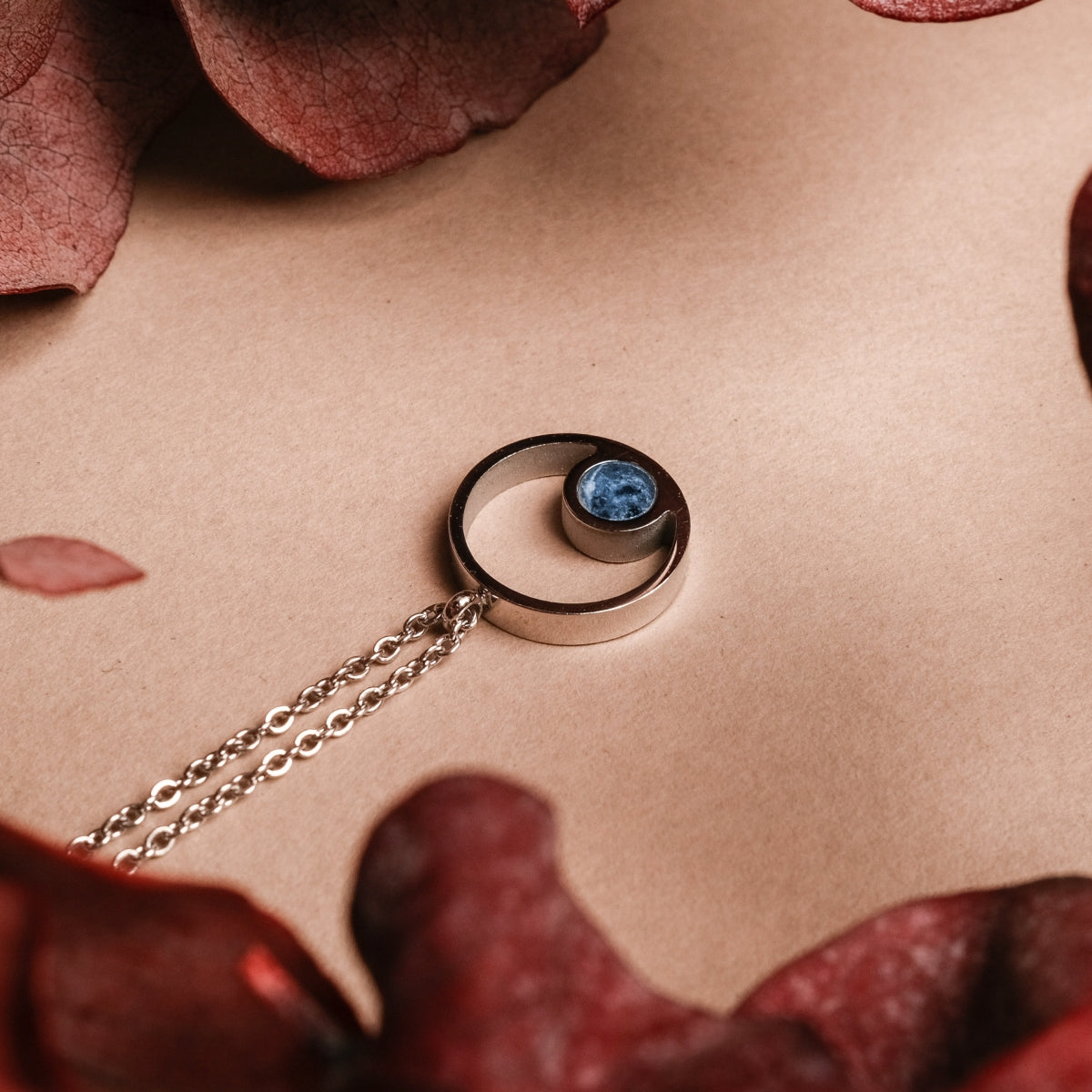 Collier "Pigment Collier" au design en marbre et argent, avec un style élégant et artistique sur fond neutre.
