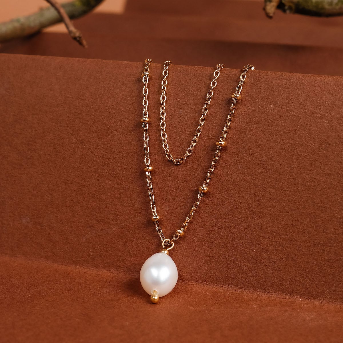 "Panoramic Collier", un collier en or avec des accents de perles blanches, style élégant.