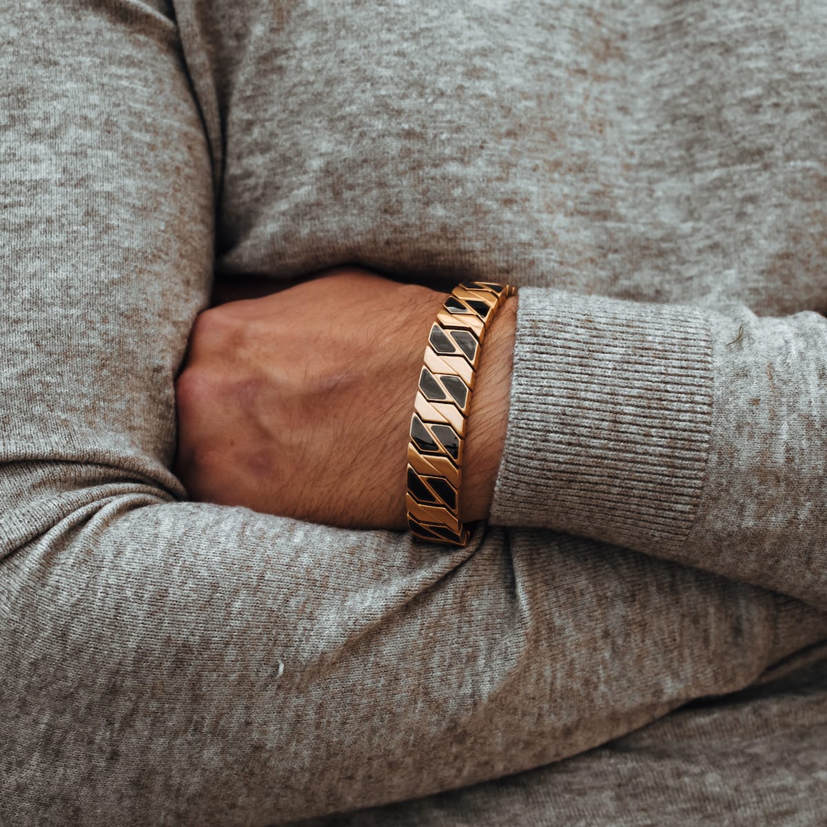 Pulsera "Baritone" con un elegante arce y diseño de oro en una pose de arma plegada.