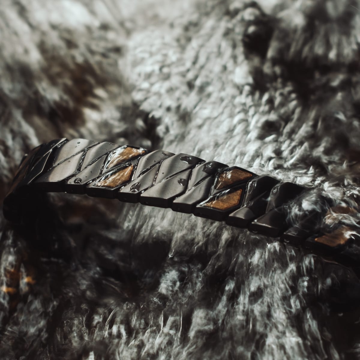 "Baritone", una elegante pulsera, cuenta con un arce llamativo y diseño geométrico negro en un fondo de lujo.