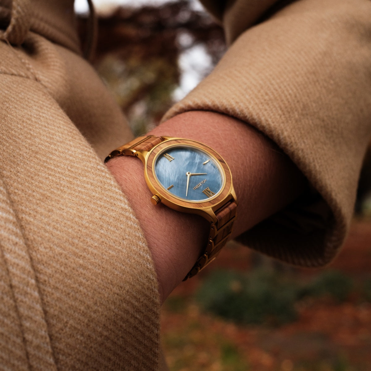 "Capri" watch featuring a sleek gold-tone design and a unique blue nacre dial for a sophisticated look.