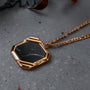 "Scalar Ketting" ketting met een zeshoekige marmeren hanger met een gouden ketting, met een moderne en elegante stijl.