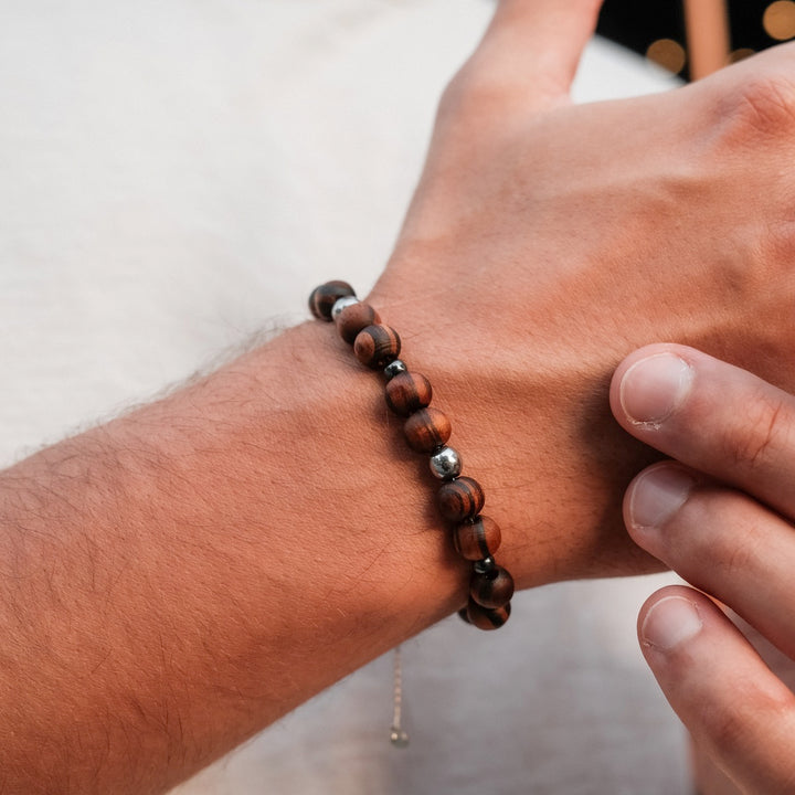 Pulsera "Superset" con cuentas de hematita y nuez, mostrando un diseño natural y elegante en una muñeca.