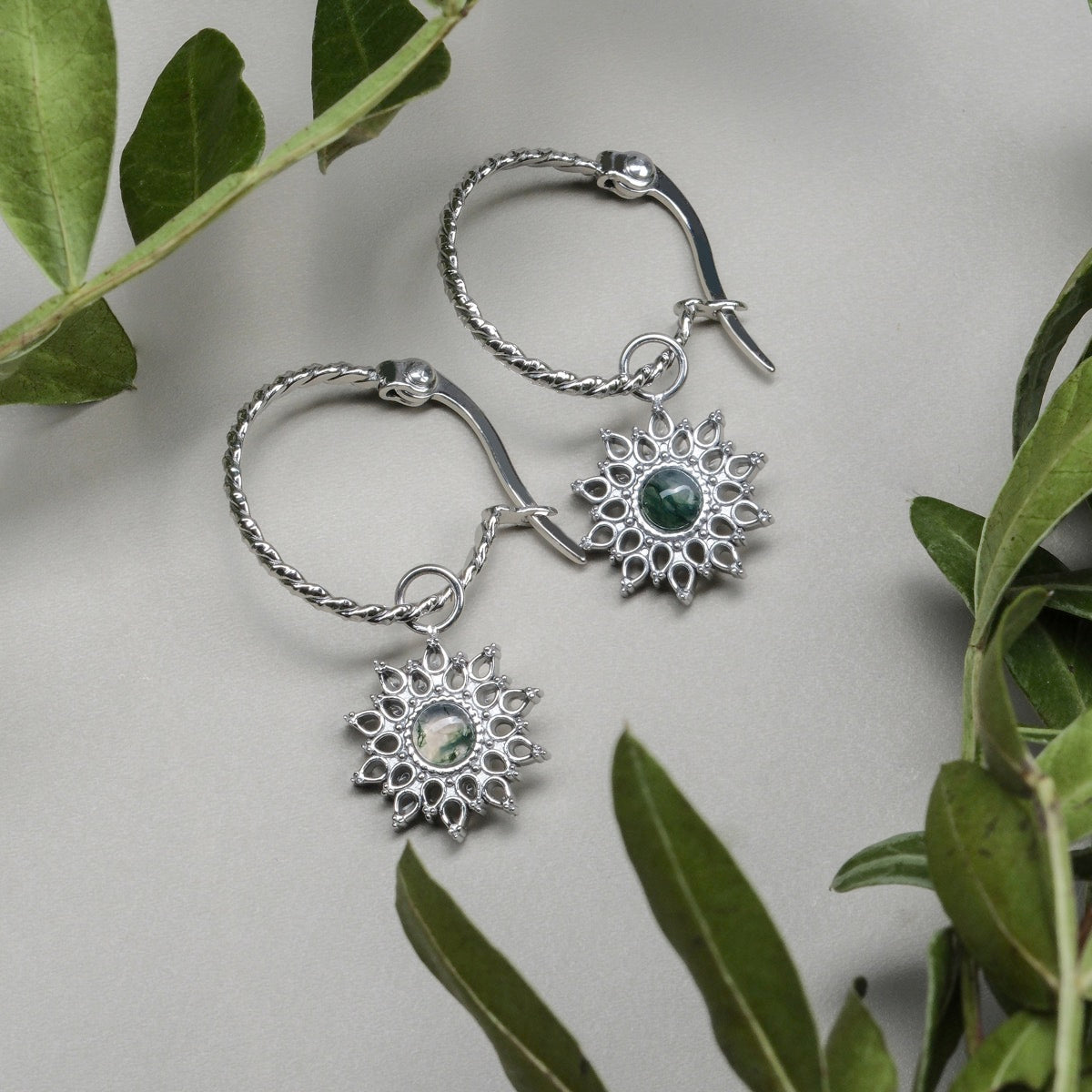 "Suncatcher Earrings": elegant earrings with a marble and silver design, showcasing a sunburst style.